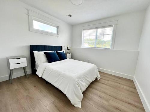a white bedroom with a bed and a window at Dream Palace with HOT TUB-Game Room-Fire Pit-5BR-3BA in Traverse City