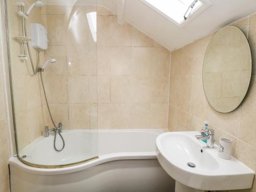 a bathroom with a tub and a sink and a shower at No 2 New Cottages in Pembroke