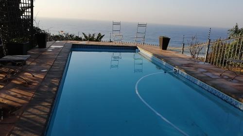 a swimming pool with a view of the ocean at Dolphin Point B&B in Amanzimtoti