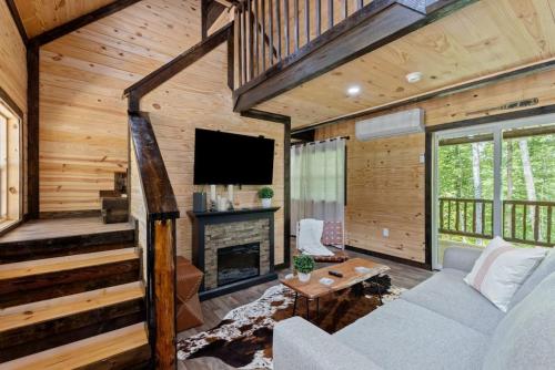 a living room with a couch and a fireplace at Private Cabin w King Bed and Private Hot Tub in Rogers