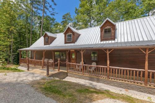 a log cabin with a porch and a metal roof at Private Cabin w King Bed and Private Hot Tub in Rogers