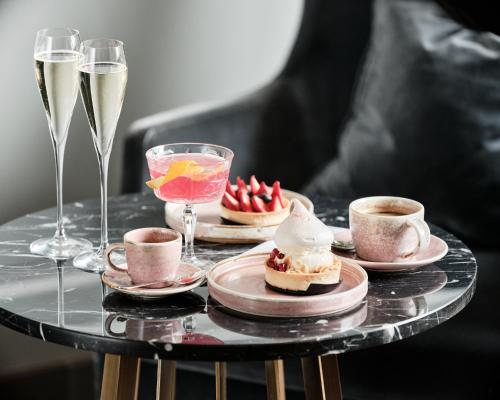 a table with cups and plates of desserts and glasses of champagne at InterContinental Warszawa by IHG in Warsaw