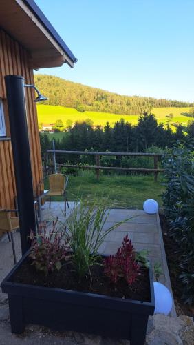 a patio with a bench and flowers in a garden at Apartment Schloffer in Weiz