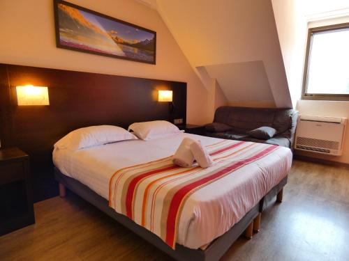 Un dormitorio con una cama con una toalla. en Hotel Be Guest Limoges Sud - Complexe BG, en Limoges