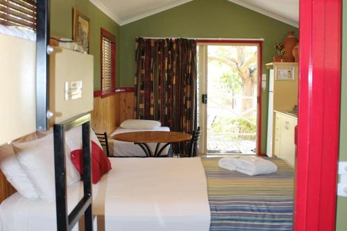 1 dormitorio con 2 camas, mesa y ventana en Big4 Aussie Outback Oasis Holiday Park, en Charters Towers