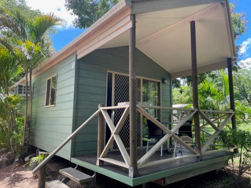 a green tiny house with a porch at Aussie Outback Oasis Holiday Park in Charters Towers