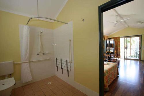 a bathroom with a shower and a bed in a room at Big4 Aussie Outback Oasis Holiday Park in Charters Towers