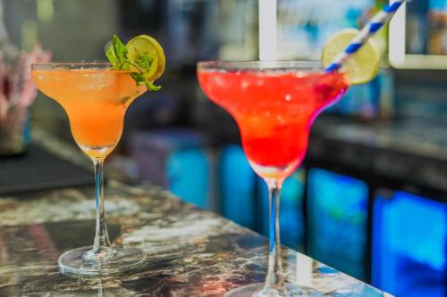 two cocktails sitting on top of a bar at Hotel Escala By Levelup in Amritsar