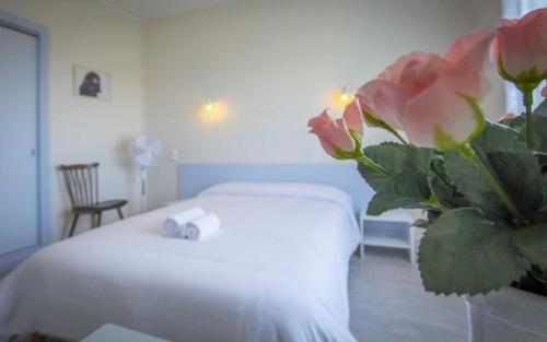 Le Relais de la route bleue في Saint-Loup: غرفة في الفندق بها سرير و مزهرية من الزهور