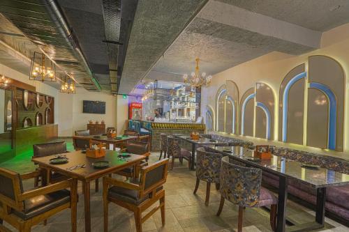 a restaurant with tables and chairs and a bar at Hotel Escala By Levelup in Amritsar
