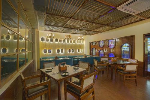 a restaurant with tables and chairs in a room at Hotel Escala By Levelup in Amritsar
