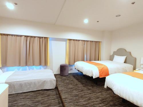 a hotel room with two beds and a window at Hotel Montoview Yonezawa in Yonezawa