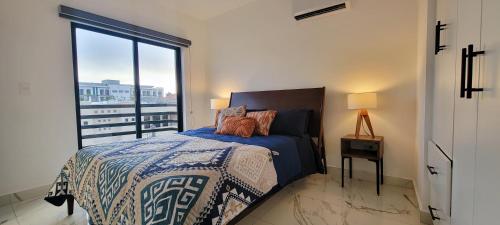 a bedroom with a bed and a large window at New Luxury Condo in Mazatlán