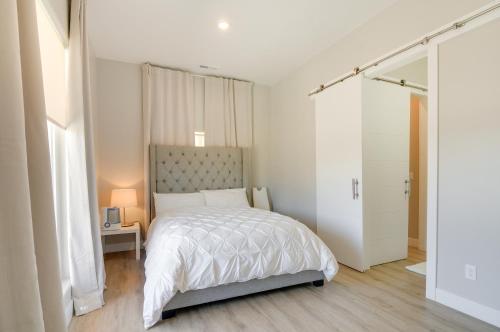 a white bedroom with a bed and a window at Lake Powell Sunrise Villa by Antelope Canyon with firepit and scenic views in Big Water