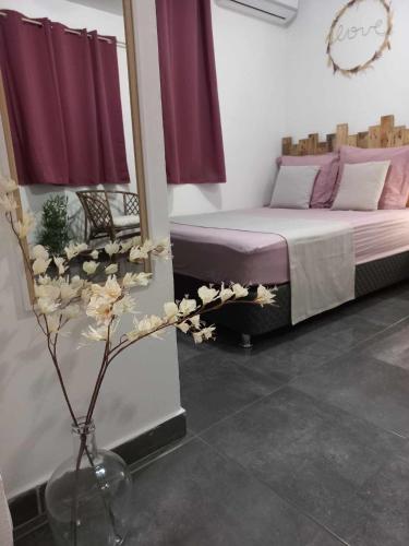 a bedroom with a bed and a vase with flowers at Corail Azur Terre Sainte in Saint-Pierre