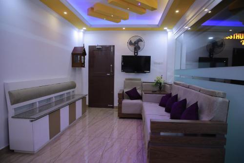 a lobby with couches and a tv in a room at Kausthubhom Residency in Tiruvalla