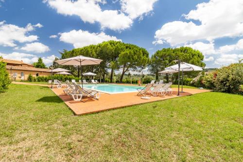 una piscina con sillas y sombrillas en un patio en Family Apartments With Pool Near Volterra - Happy Rentals, en Pomarance