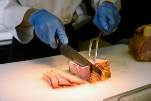 a person cutting a piece of meat with a knife at Walden Hotel in Yilan City