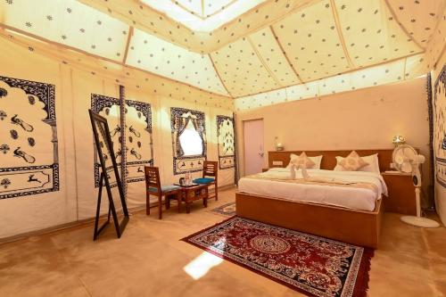 a bedroom with a bed in a room with a ceiling at Excellent Desert Safari camp in Sām