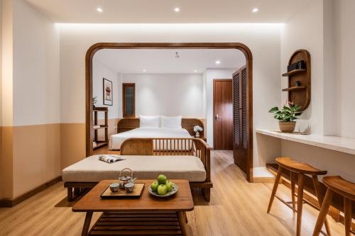 ハノイにあるLe Parfum Apartment and Hotelのベッドとテーブルのあるホテルの部屋