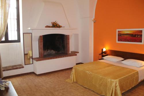 a bedroom with a bed and a fireplace at B&B Masseria Donna Carlotta in Serrano