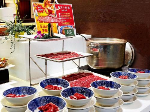 a buffet with bowls of food on a table at Walden Hotel in Yilan City