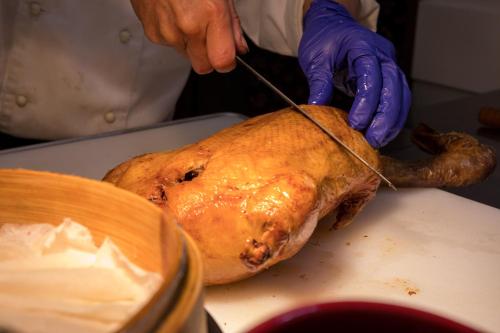 a person is cutting a turkey with a knife at Walden Hotel in Yilan City