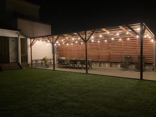 a pavilion with tables and lights on it at night at 海まで徒歩5分-BBQ バレルサウナ ジャグジー ペットOKの貸切villa in Ichinomiya