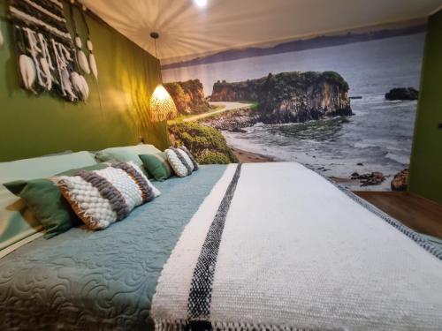 a bedroom with a large bed with a painting on the wall at HOTEL BOUTIQUE TIERRA DE ISLAS Chiloé in Castro