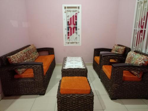 een woonkamer met 3 stoelen en een bank bij AL IZZAM HOMESTAY in Pagaralam