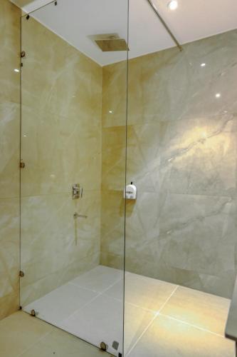 a shower with a glass door in a bathroom at Hotel Escala By Levelup in Amritsar
