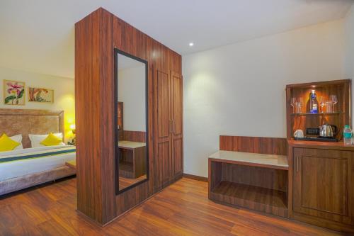 a room with a bedroom with a bed and a mirror at Hotel Escala By Levelup in Amritsar