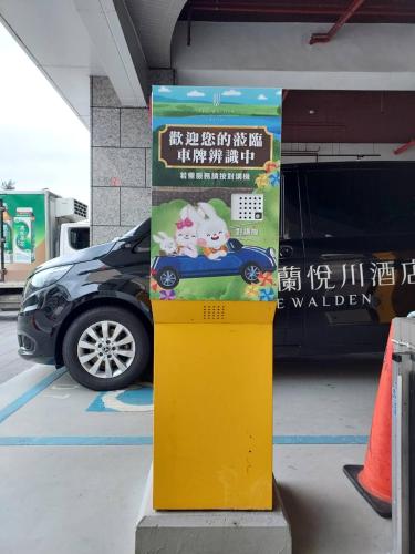a sign in a parking lot next to a car at Walden Hotel in Yilan City