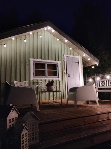 une maison avec une table et des chaises sur une terrasse la nuit dans l'établissement Metsatuule puhkeküla, à Hiiumaa