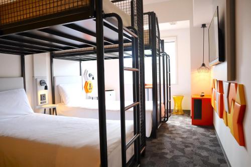 Zimmer mit 2 Etagenbetten und einem TV in der Unterkunft ibis Styles Tokyo Bay in Urayasu