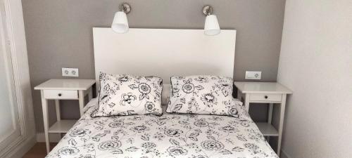 - une chambre avec un lit avec deux oreillers et deux tables dans l'établissement La Casita de Barrañán Playa, à Arteixo
