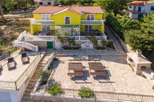 a yellow house with chairs and a patio at Seaview House Helena Apartments - Happy Rentals in Plomin