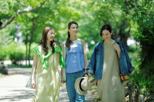three young women walking down a sidewalk at &Here TOKYO UENO in Tokyo