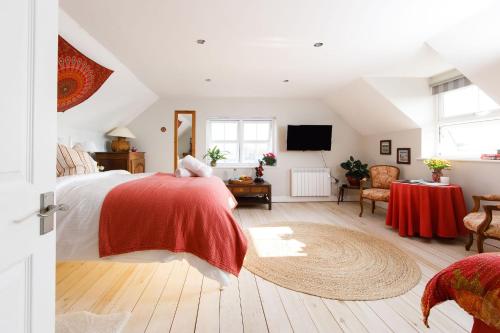 a bedroom with a bed with a red blanket at Woodfield Wellbeing in Oving