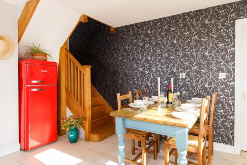 a dining room with a table and a red refrigerator at Woodfield Wellbeing in Oving