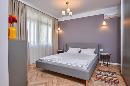 a bedroom with a bed and a vase with flowers at Florance Rentals Luxury Apartments in Saint Vlas in Sveti Vlas