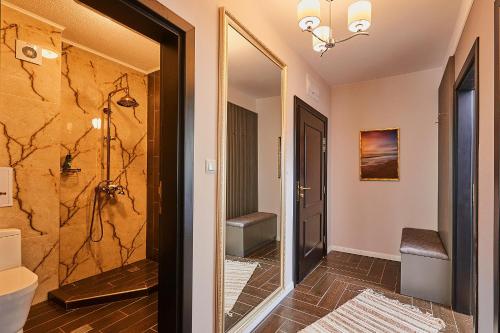 uma casa de banho com uma cabina de duche ao nível do chão e um espelho. em Florance Rentals Luxury Apartments in Saint Vlas em Sveti Vlas