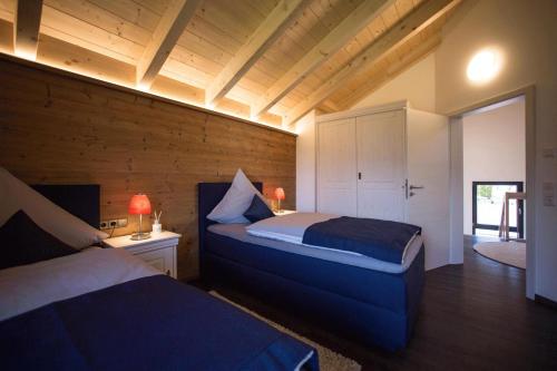 1 Schlafzimmer mit 2 Betten in einem Zimmer mit Holzwänden in der Unterkunft Châlets de la Liberté B in Oberstaufen
