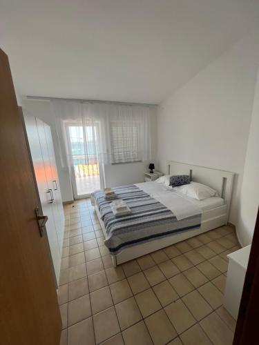 1 dormitorio con 1 cama y suelo de baldosa en Apartments Kulic, en Tisno