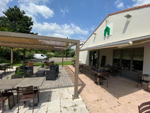 a patio with tables and chairs outside of a building at Campanile NATURE - Cahors in Cahors