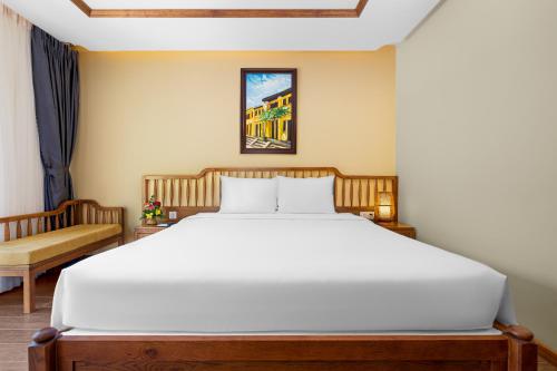 a bedroom with a large white bed and a couch at Fivitel Cổng Trời Đông Giang - Fivitel Đông Giang Heaven's Gate in Dong Giang