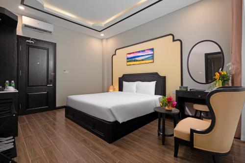 a bedroom with a bed and a desk and a chair at Fivitel Cổng Trời Đông Giang - Fivitel Đông Giang Heaven's Gate in Dong Giang