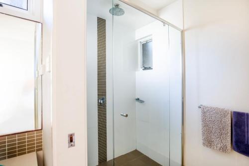 a shower with a glass door in a bathroom at Aqua Beachfront - Pet Friendly - 2 Mins Walk to Beach in Culburra Beach