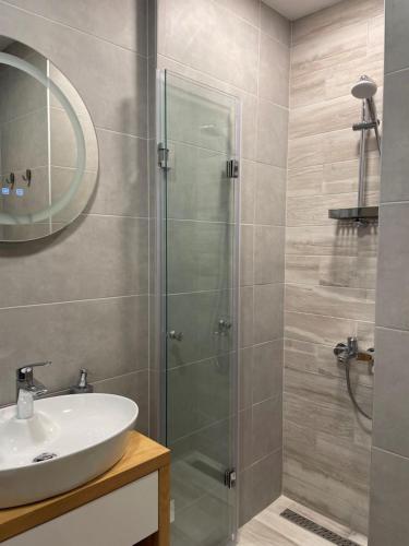 a bathroom with a glass shower and a sink at SUNNY STUDIO AZUR in St. St. Constantine and Helena