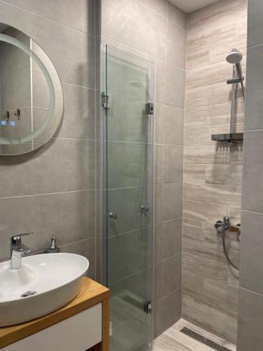 a bathroom with a glass shower and a sink at SUNNY STUDIO AZUR in Saints Constantine and Helena